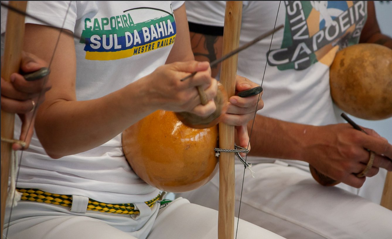 Gros plan mains jouant le berimbau